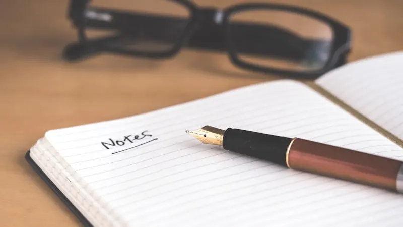 Glasses beside an open notebook labeled "Notes" — understanding French verb groups